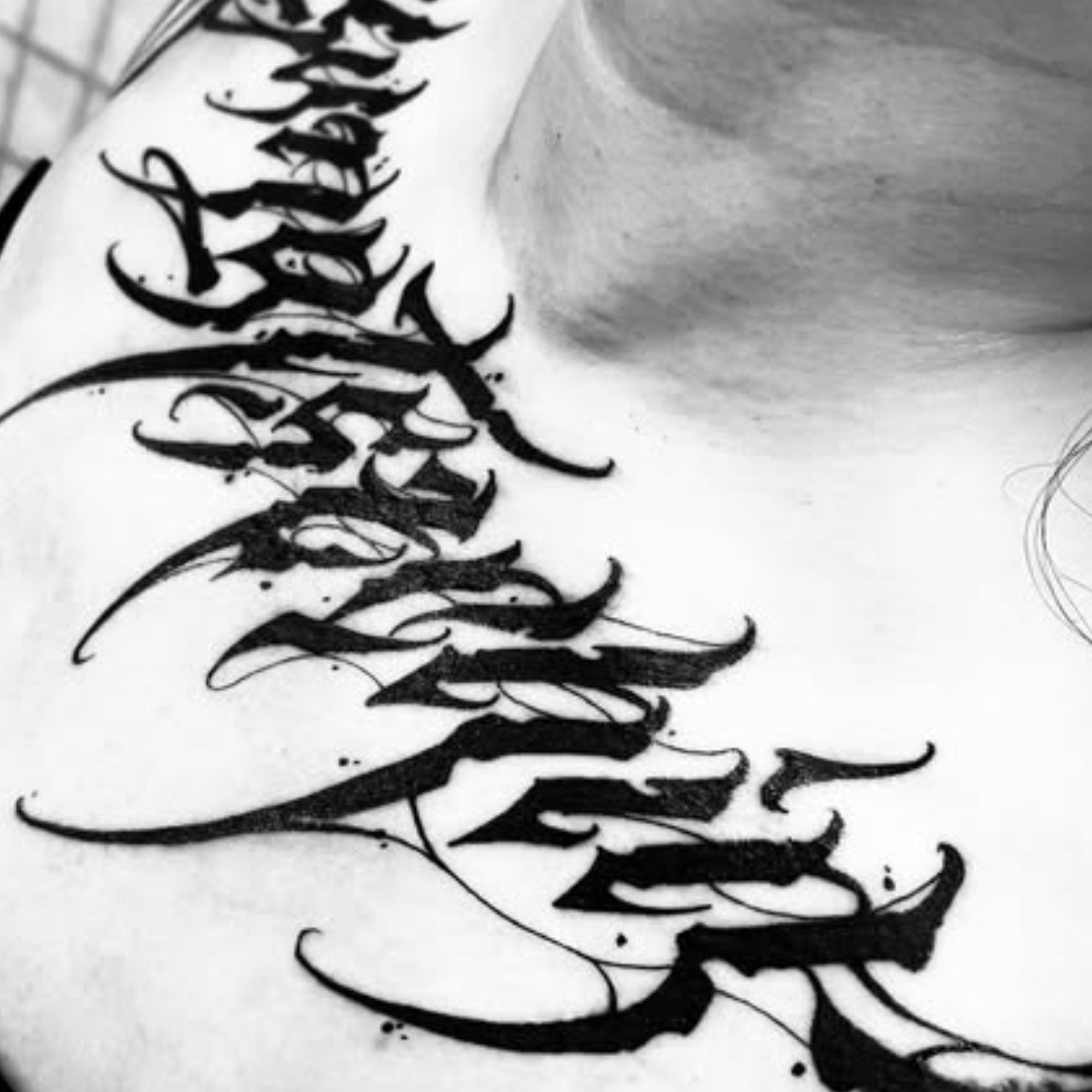 Black calligraphy tattoo on a person's arm